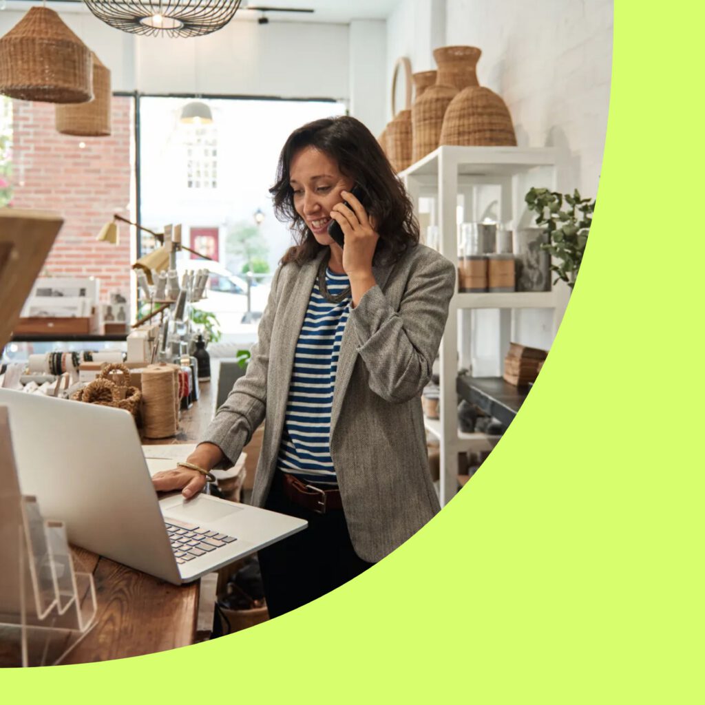 Photo of a busy retailer on the phone and computer